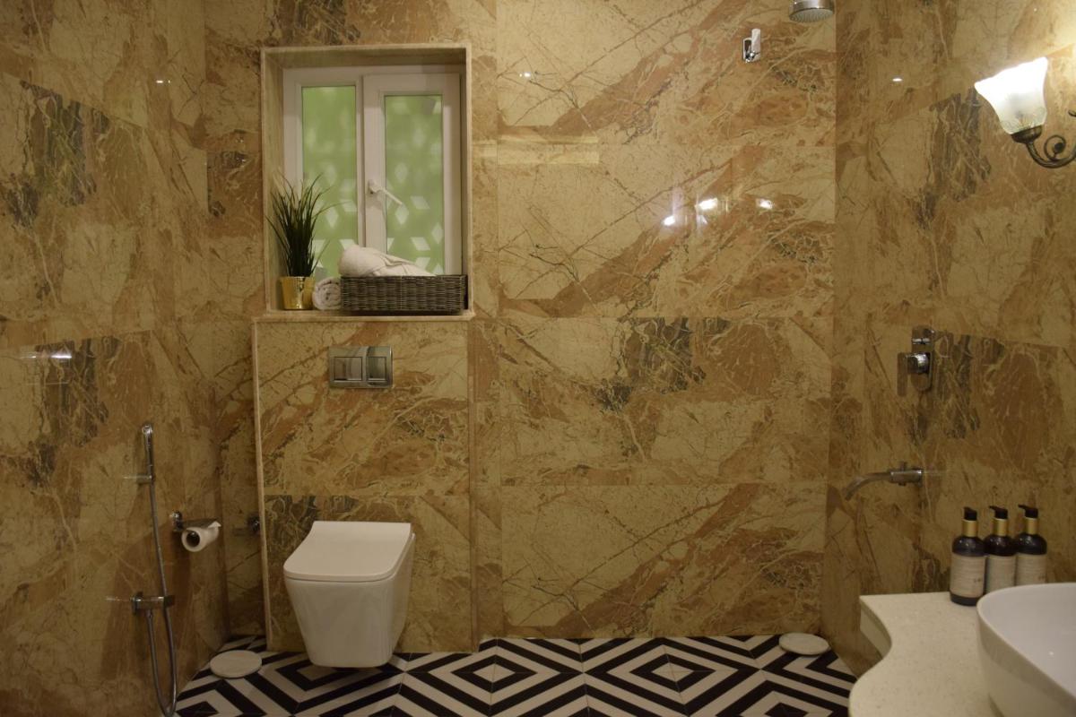 a bathroom with a toilet and a sink and a mirror at Dileep Kothi - A Royal Boutique Luxury Suites in Jaipur in Jaipur