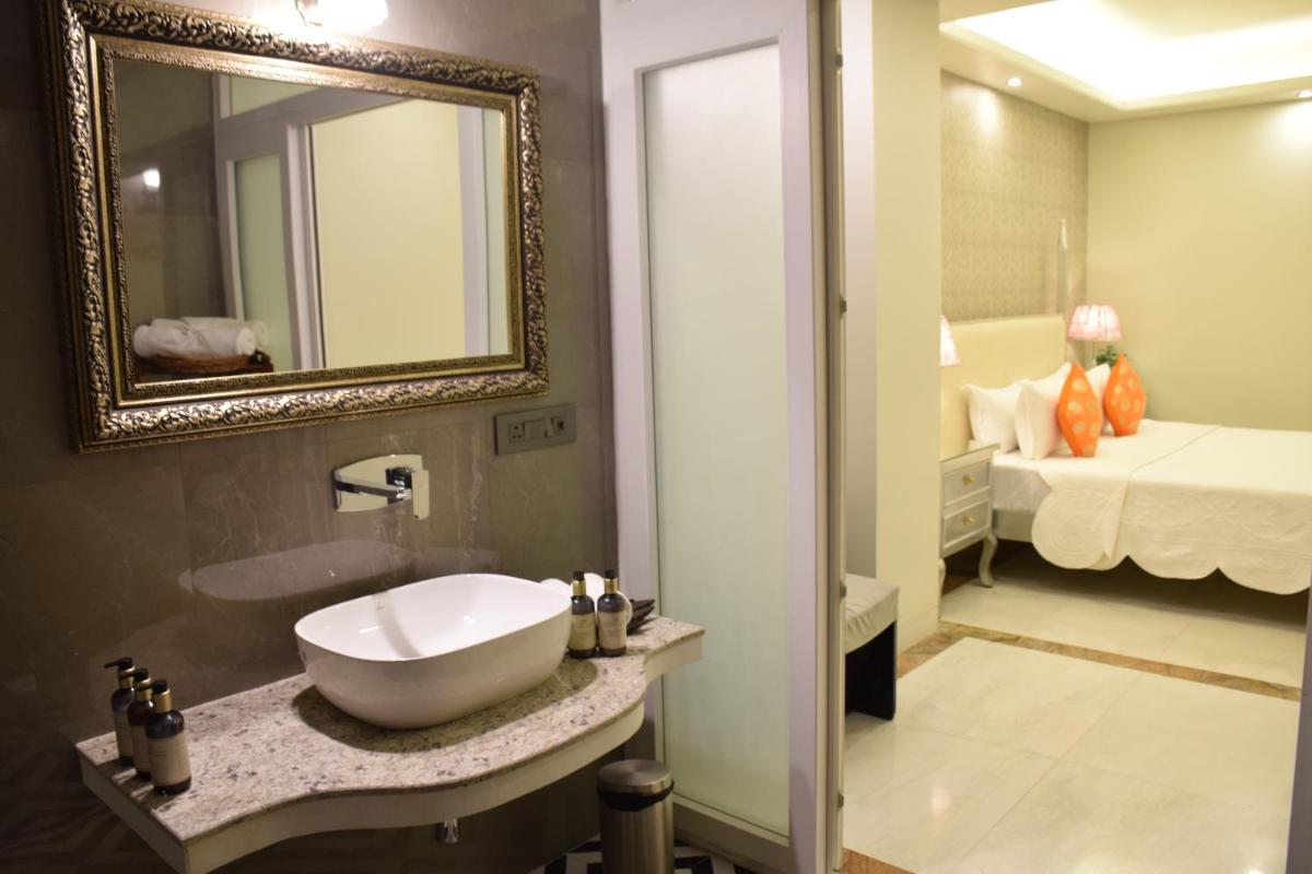 a bathroom with a sink and a mirror and a bed at Dileep Kothi - A Royal Boutique Luxury Suites in Jaipur in Jaipur