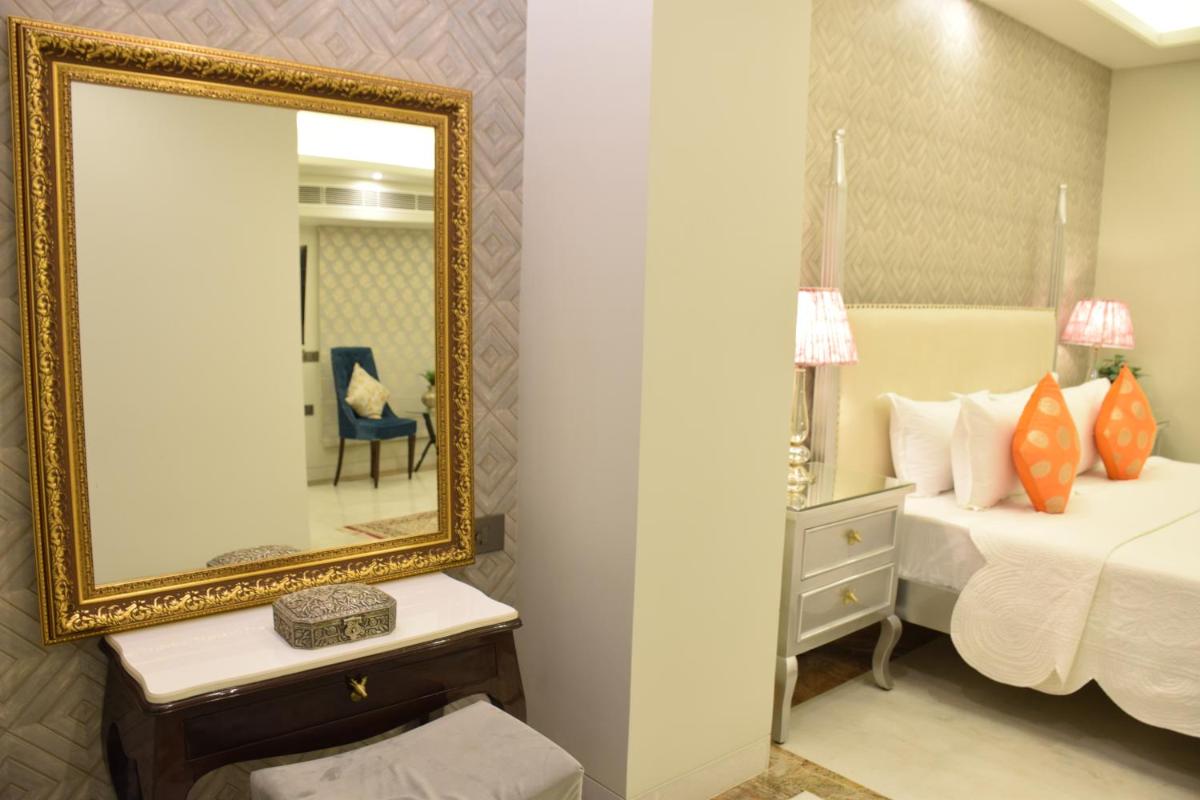 a bedroom with a mirror and a bed at Dileep Kothi - A Royal Boutique Luxury Suites in Jaipur in Jaipur