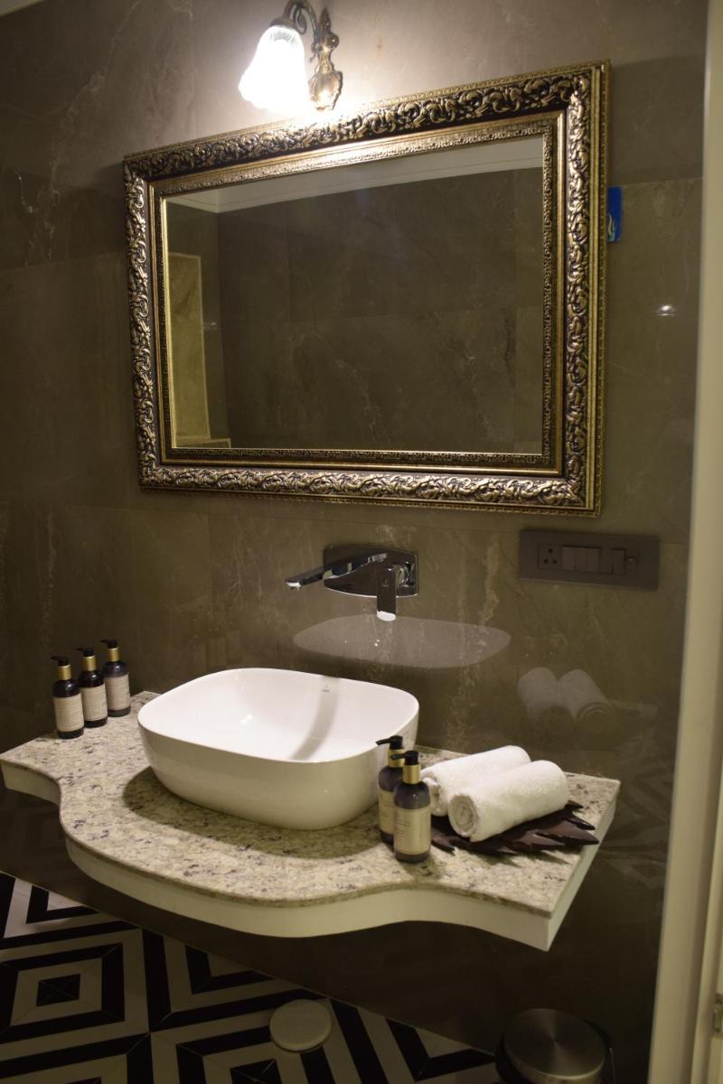 a bathroom with a white sink and a mirror at Dileep Kothi - A Royal Boutique Luxury Suites in Jaipur in Jaipur