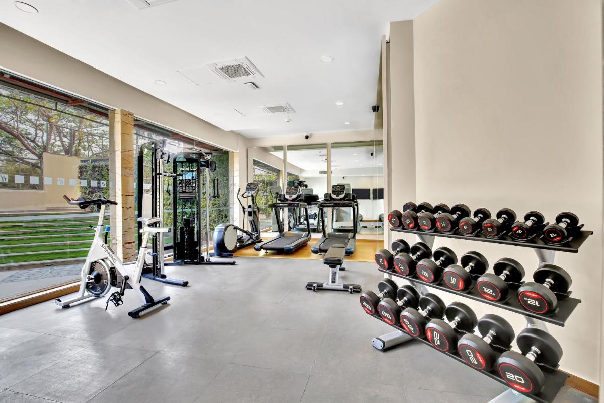 a gym with several treadmills and exercise machines at Holiday Inn Goa Candolim in Candolim a gym with several treadmills and exercise machines at Holiday Inn Goa Candolim in Candolim