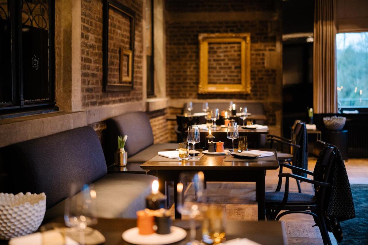 ein Restaurant mit Tischen und Stühlen in einem Raum in der Unterkunft Schlosshotel Hugenpoet in Essen