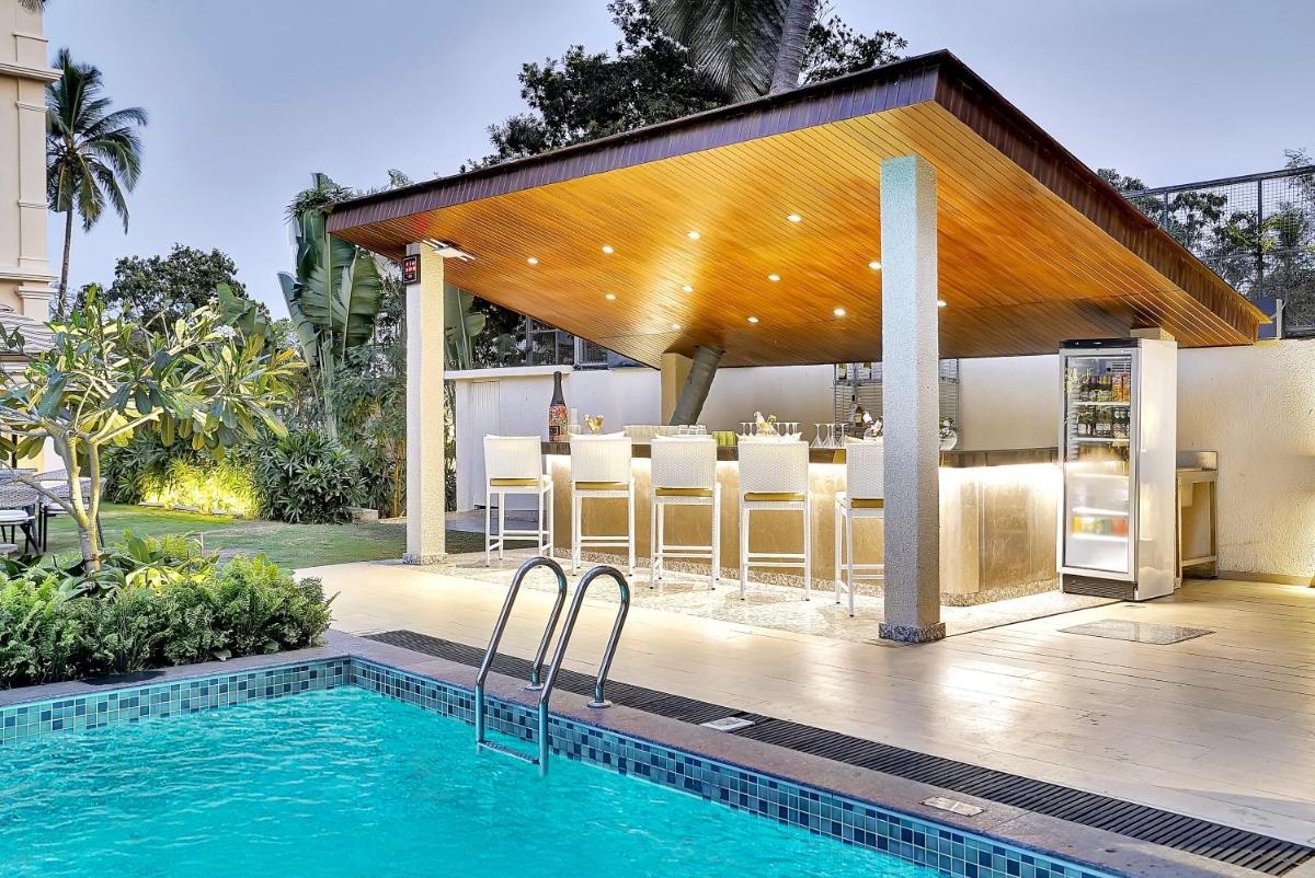 a house with a swimming pool and a pavilion at Holiday Inn Goa Candolim in Candolim a house with a swimming pool and a pavilion at Holiday Inn Goa Candolim in Candolim