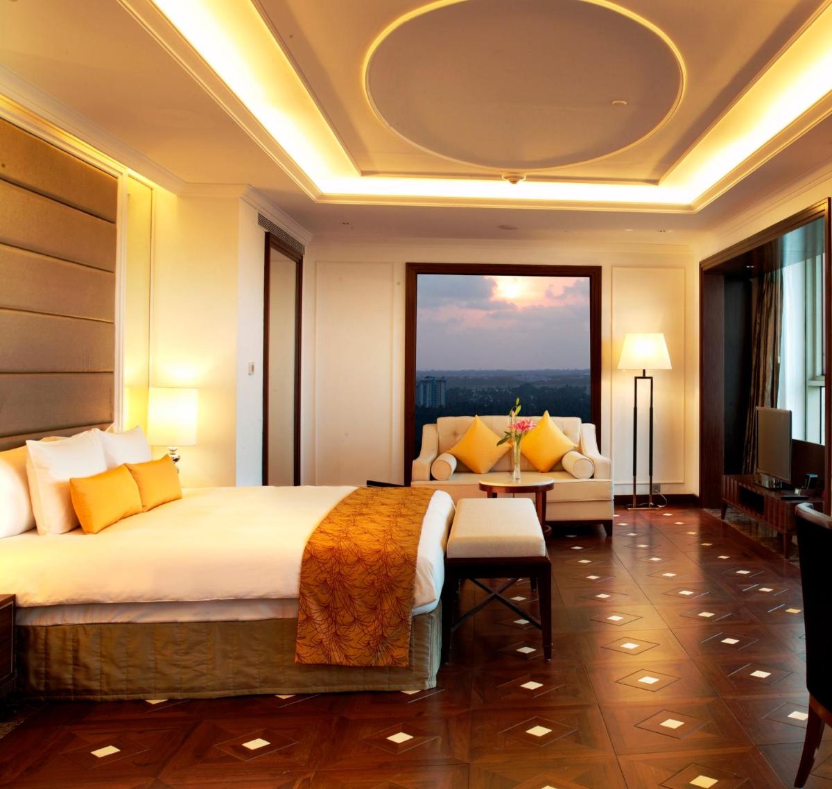 a hotel room with a large bed and a couch at Crowne Plaza Kochi by IHG in Cochin