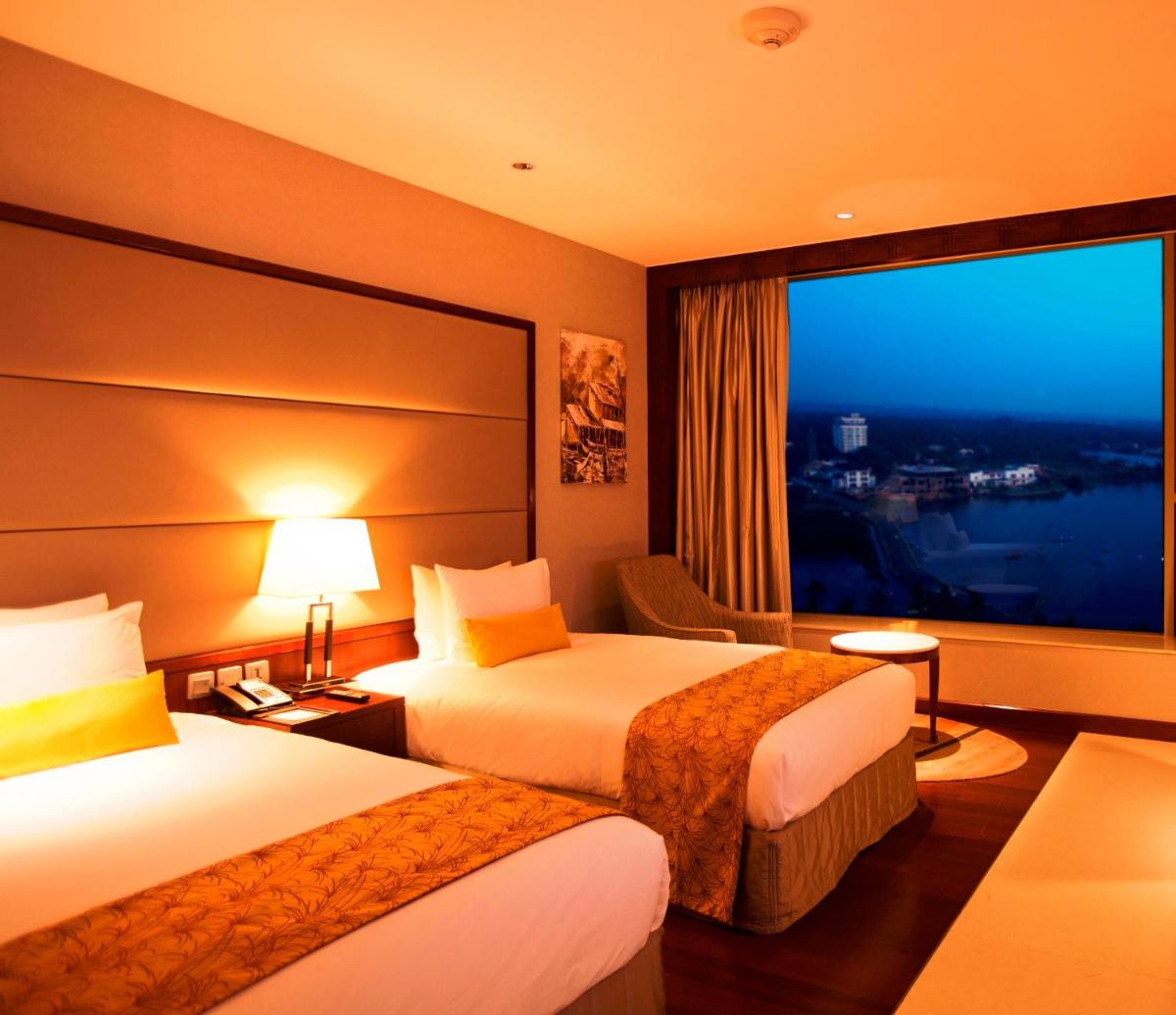 a hotel room with two beds and a large window at Crowne Plaza Kochi by IHG in Cochin