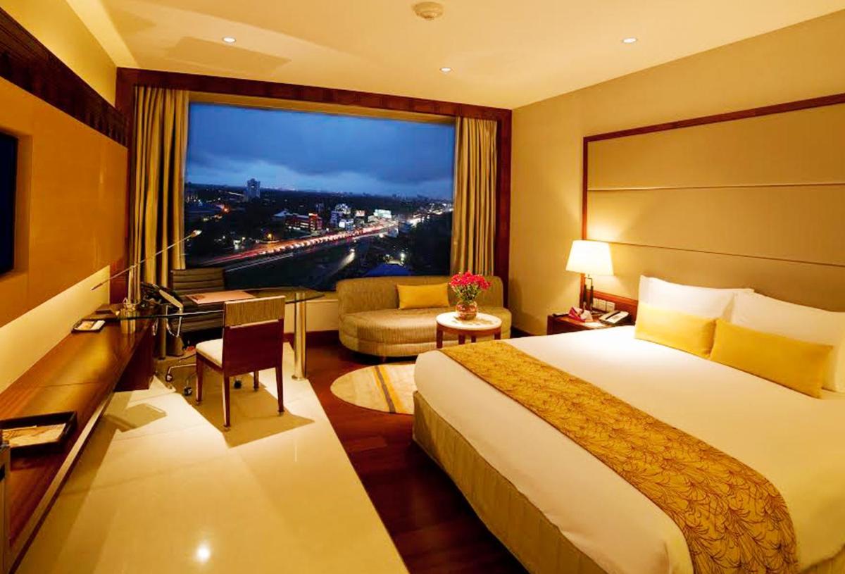 a hotel room with a bed and a large window at Crowne Plaza Kochi by IHG in Cochin