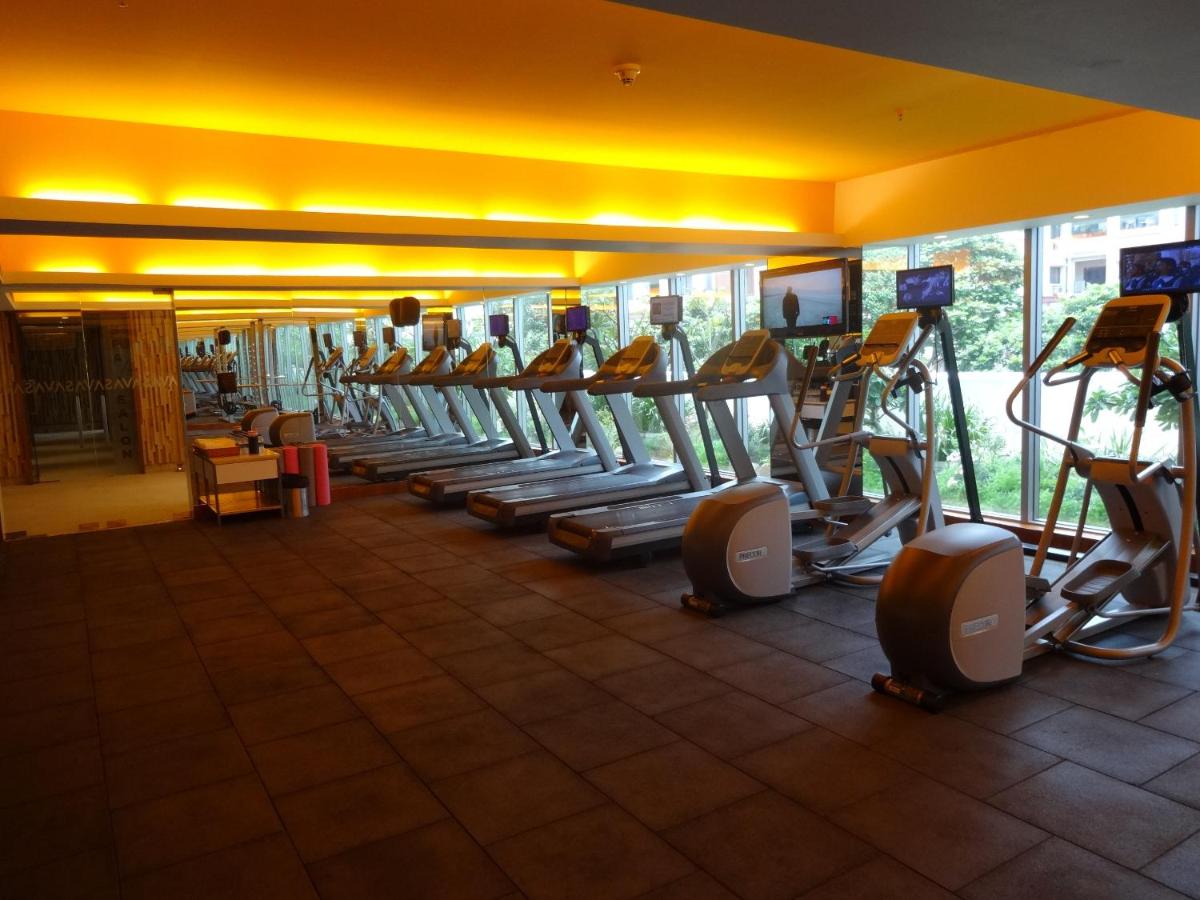 a gym with a row of treadmills and ellipticals at Avasa Hotel in Hyderabad