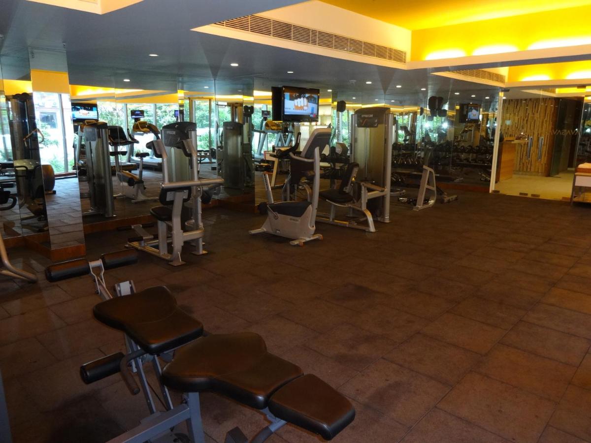 a gym with rows of exercise equipment and a television at Avasa Hotel in Hyderabad