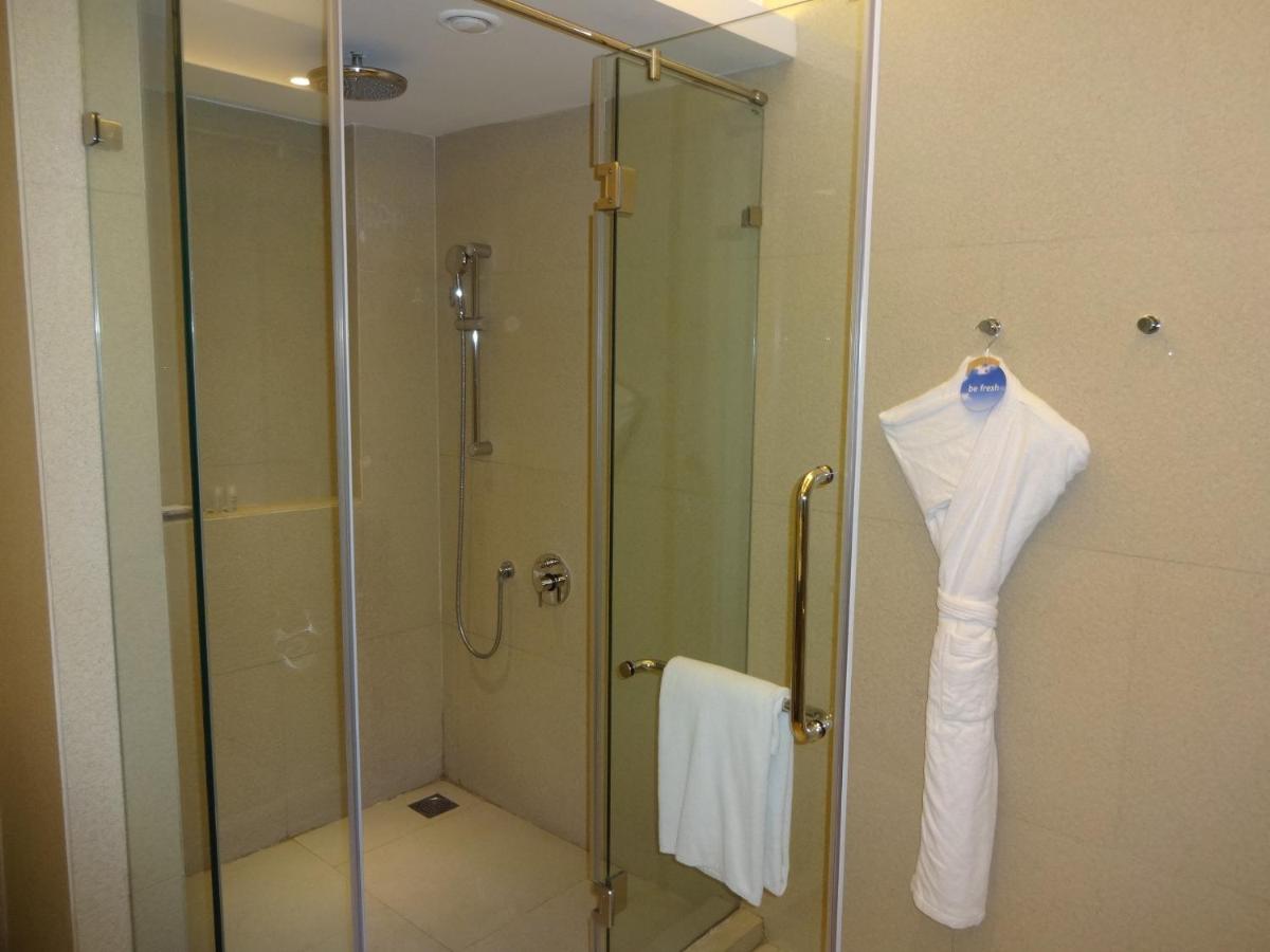 a glass shower stall with a white shirt hanging on it at Avasa Hotel in Hyderabad