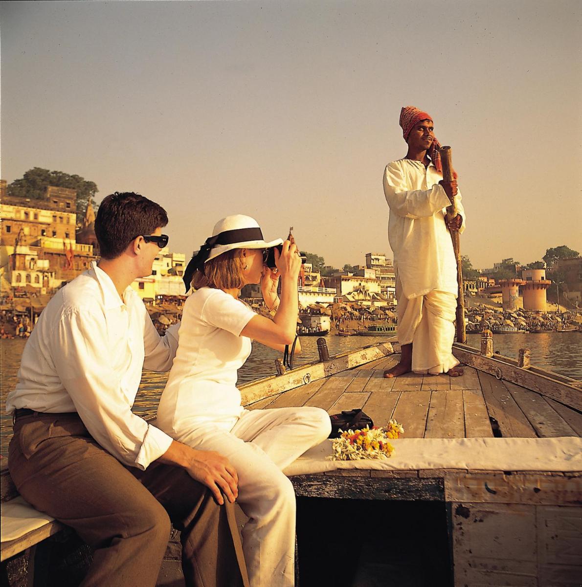 a group of people sitting on a pier taking a picture at Taj Ganges Varanasi in Varanasi