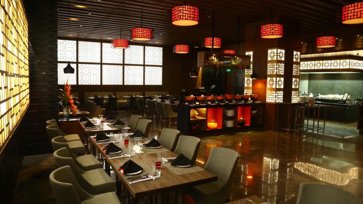 a dining room with tables and chairs and lights at Holiday Inn New Delhi Mayur Vihar Noida by IHG in New Delhi a dining room with tables and chairs and lights at Holiday Inn New Delhi Mayur Vihar Noida by IHG in New Delhi