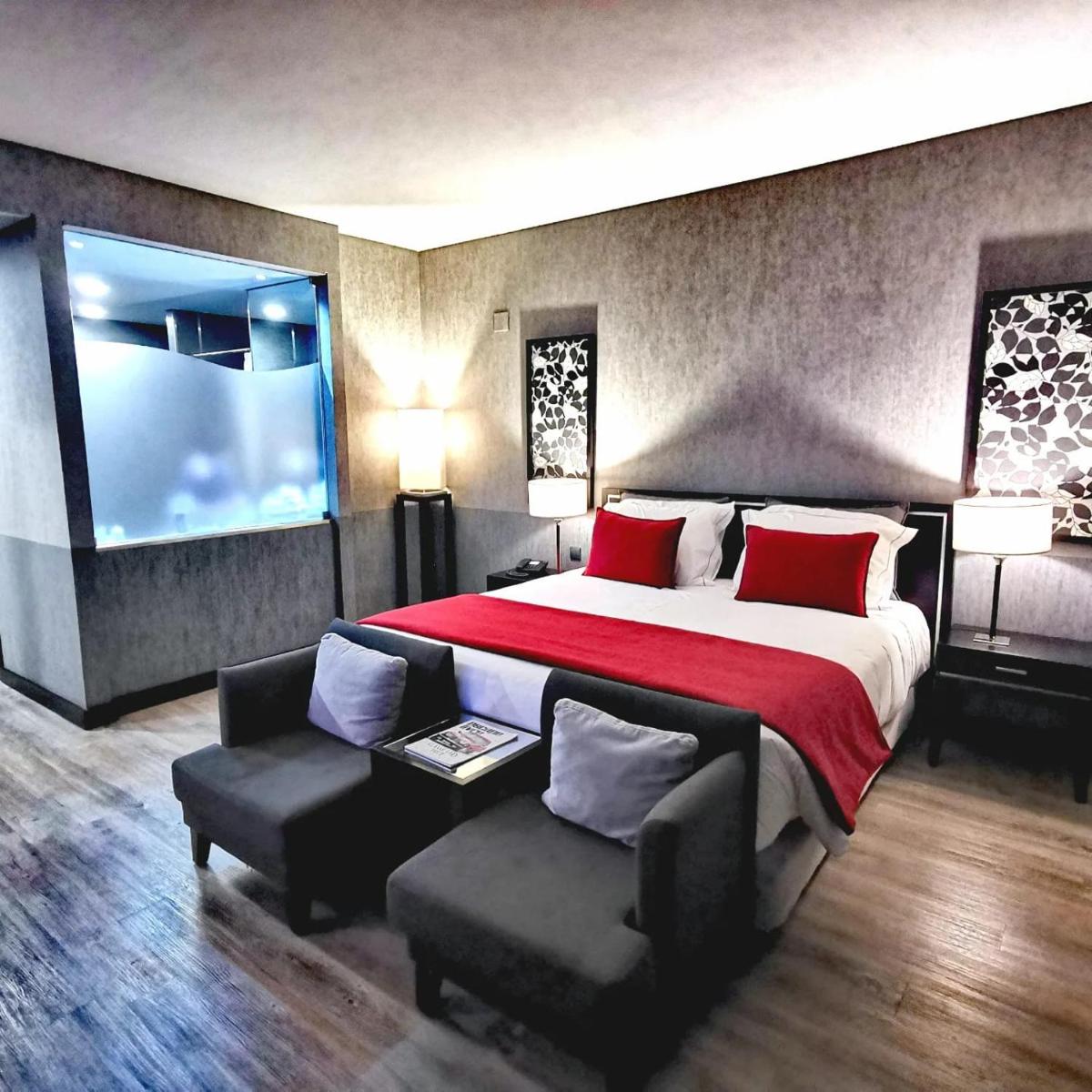 um quarto grande com uma cama grande e um sofá em Alambique - Hotel Resort & Spa no Fundão