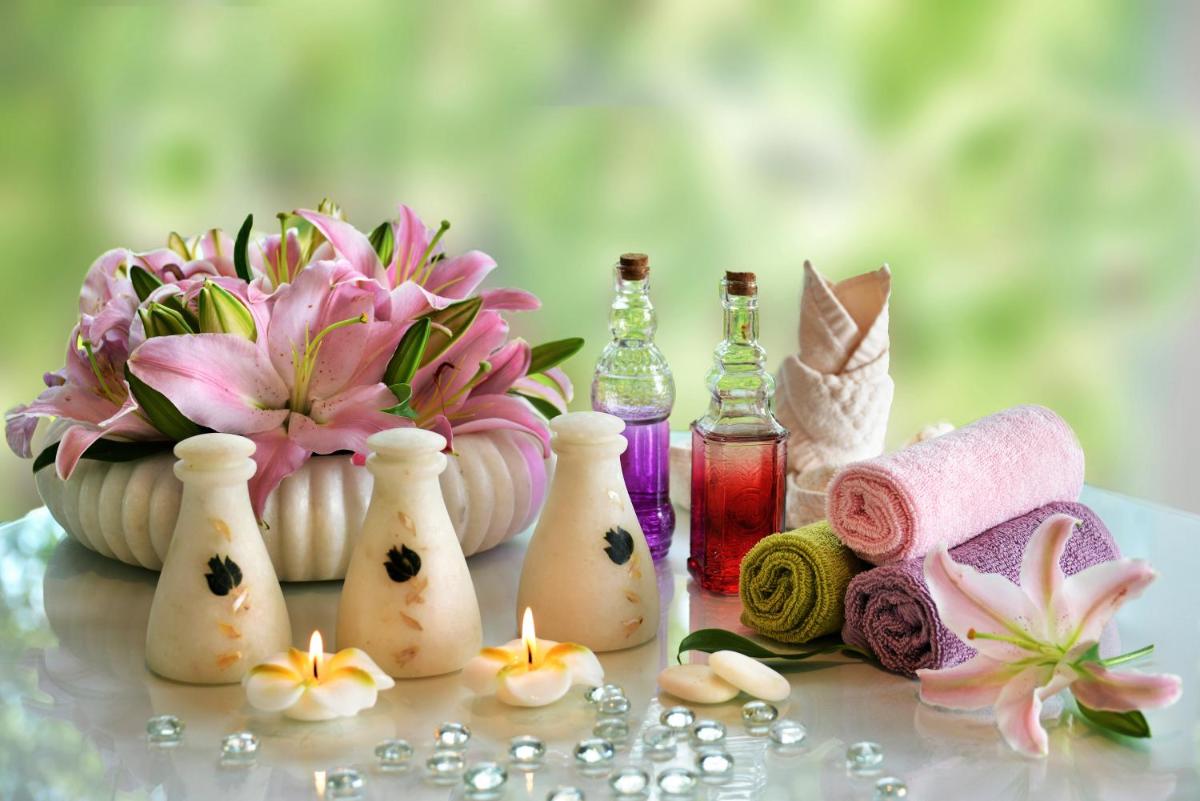a table topped with perfume bottles and a vase of flowers at Welcomhotel by ITC Hotels, Richmond Road, Bengaluru in Bengaluru