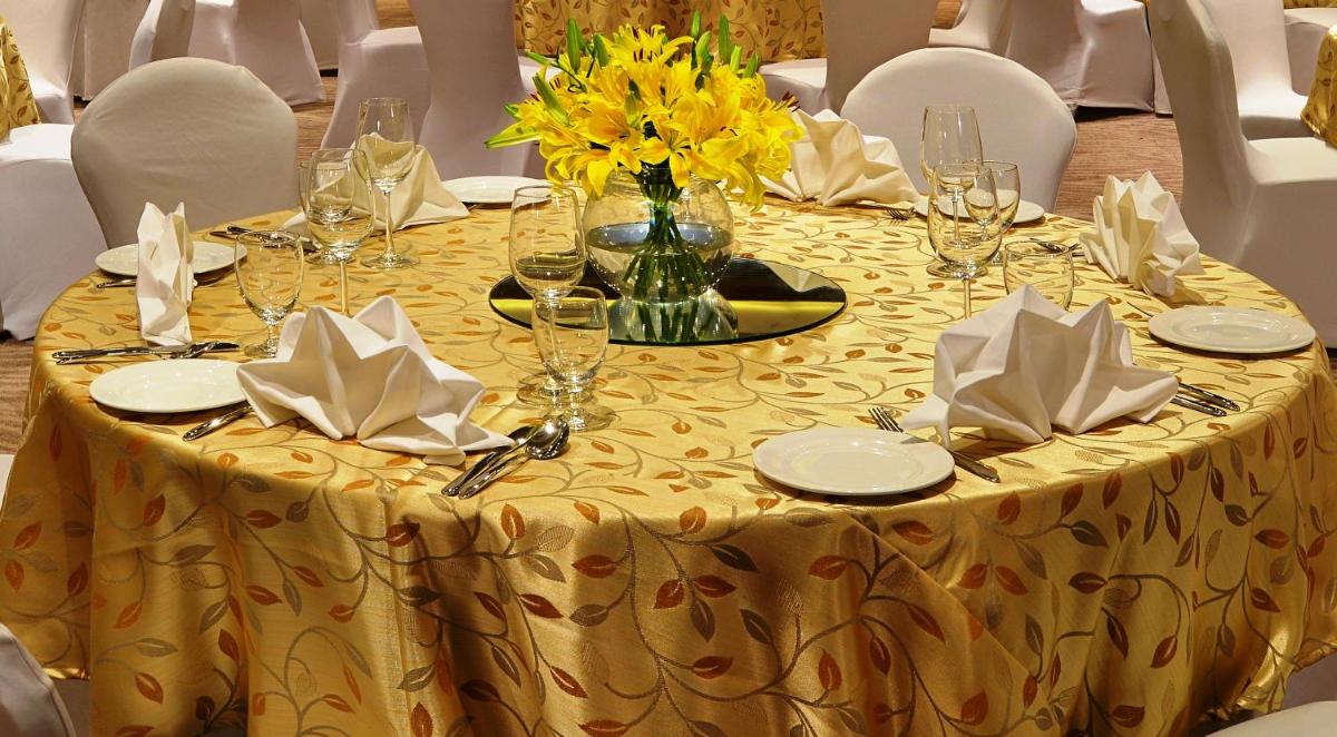 a table with a yellow table cloth and a vase of flowers at Welcomhotel by ITC Hotels, Richmond Road, Bengaluru in Bengaluru
