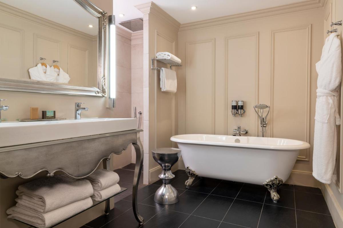 une salle de bain blanche avec une baignoire et un lavabo dans l'établissement Ermitage - Mont-Saint-Michel, à Beauvoir