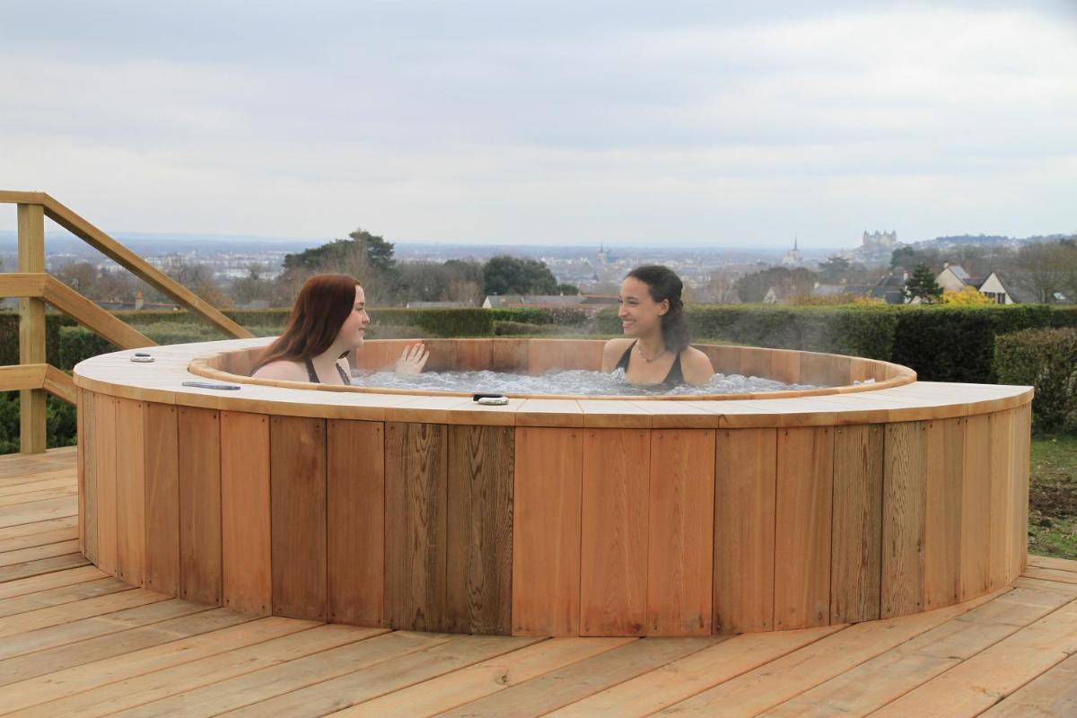 2 femmes assises dans un bain à remous sur une terrasse dans l'établissement Les Terrasses de Saumur - Hôtel & Appartements - Restaurant & Spa (Logis), à Saumur
