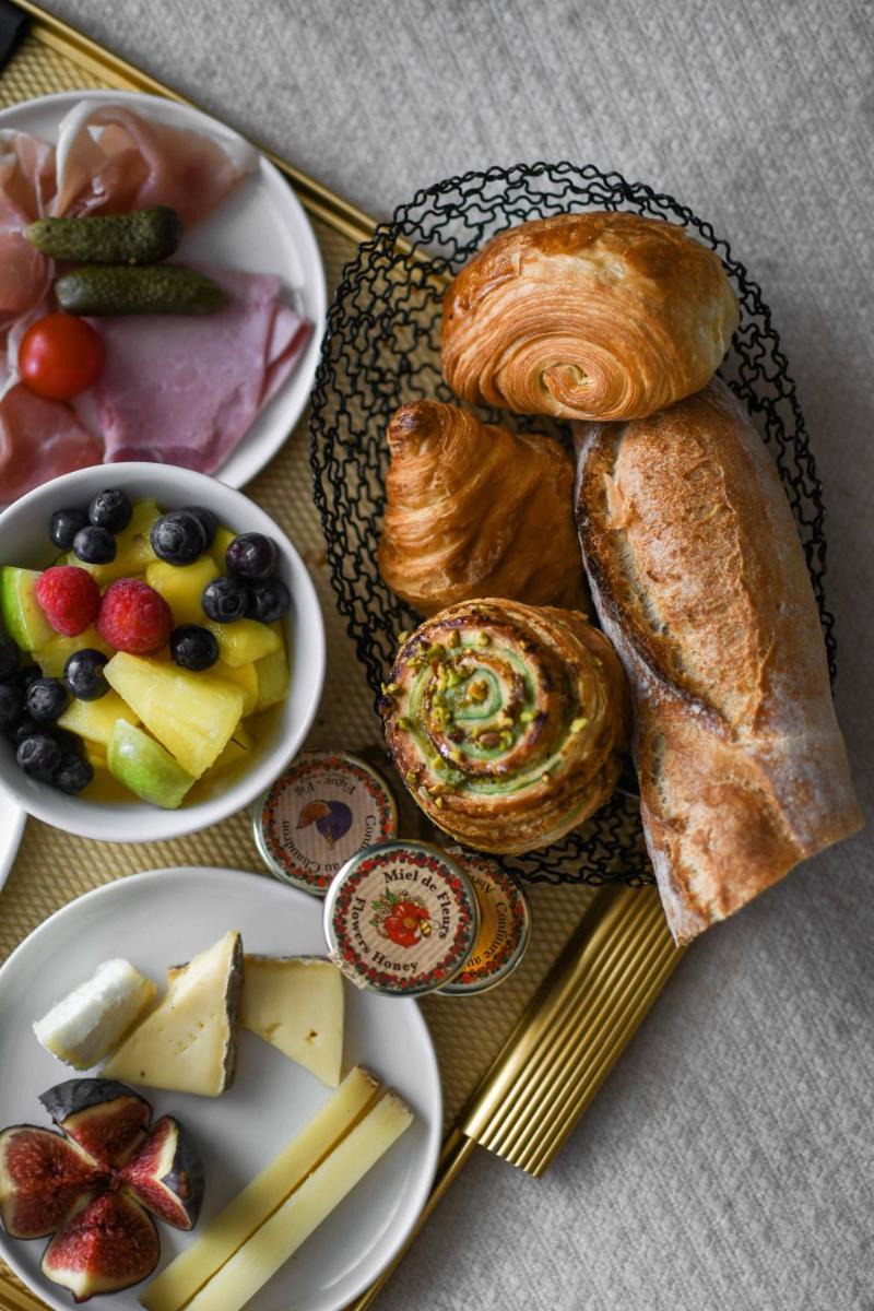 - une assiette de nourriture avec des pâtisseries et un bol de fruits dans l'établissement Hotel Parister Piscine & Spa, à Paris