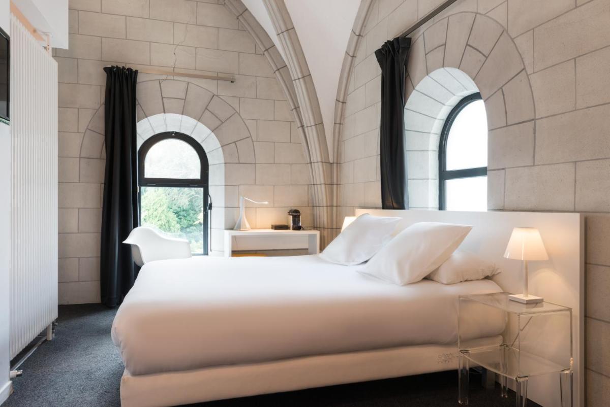une chambre avec un grand lit blanc et deux fenêtres dans l'établissement SOZO Hotel, à Nantes