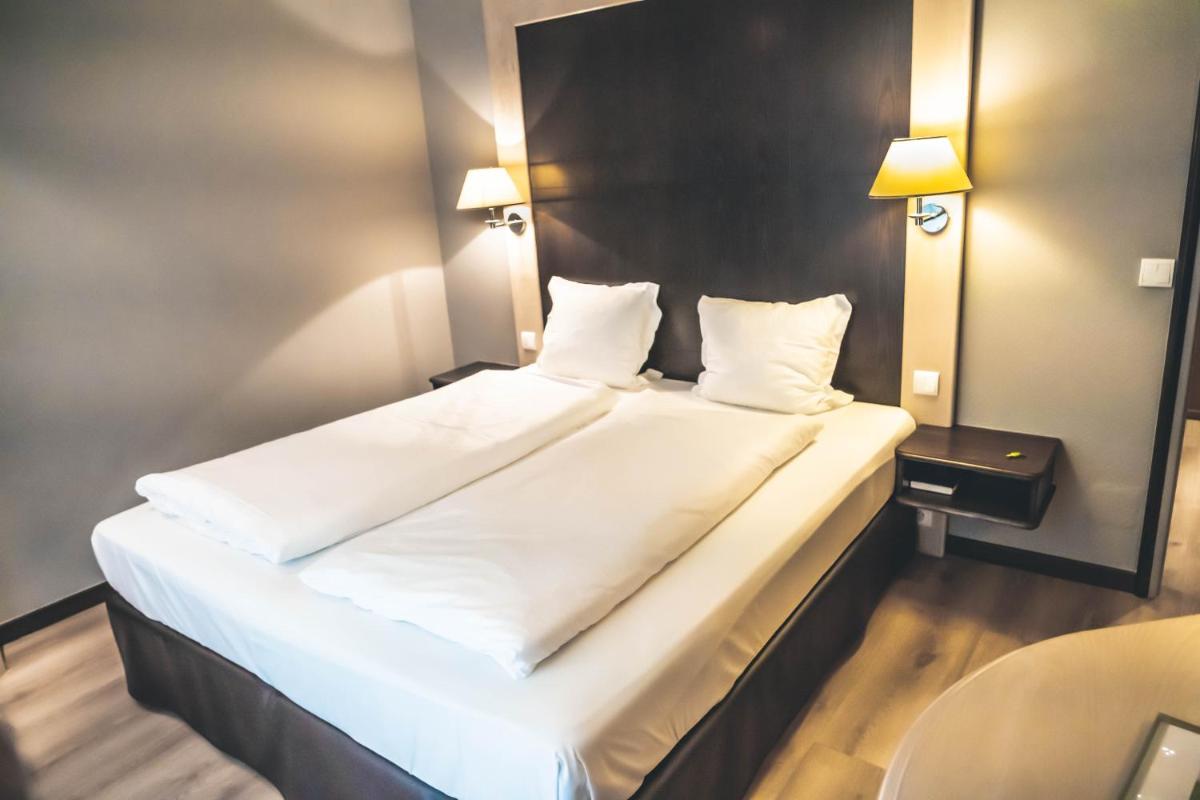 Un ou plusieurs lits dans un hébergement de l'établissement Hotel Spa et Restaurant Au Chasseur