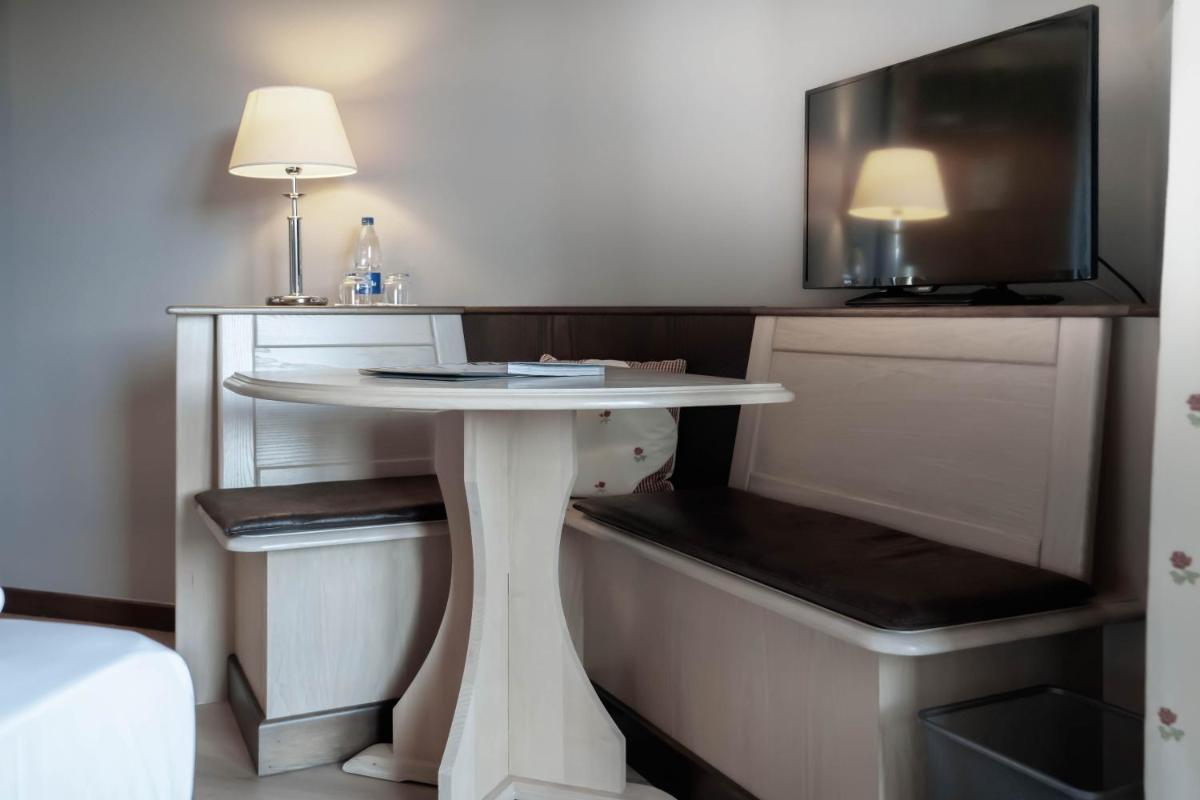 une table blanche dans une pièce avec une télévision dans l'établissement Hotel Spa et Restaurant Au Chasseur, à Birkenwald