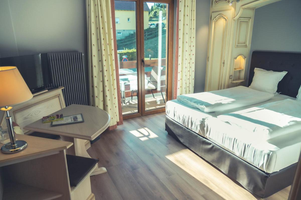 Un ou plusieurs lits dans un hébergement de l'établissement Hotel Spa et Restaurant Au Chasseur
