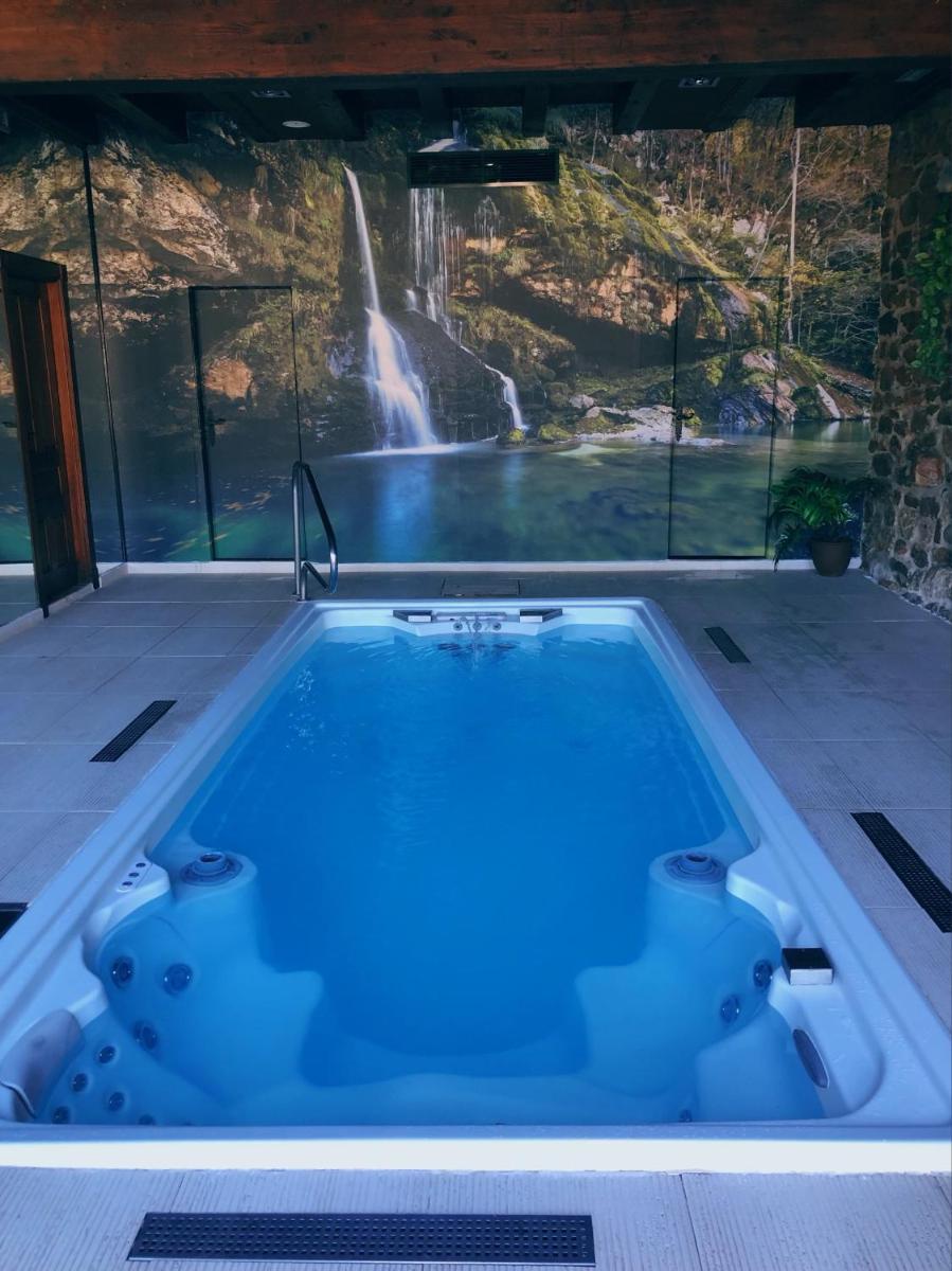 bañera de hidromasaje con cascada en el fondo en Hotel Spa Casona La Hondonada, en Terán