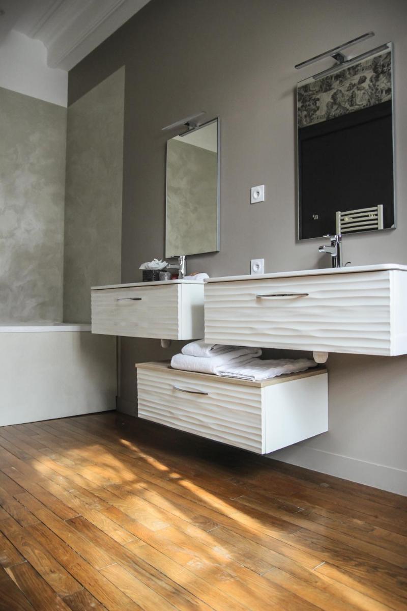 une salle de bain avec un lavabo et un miroir dans l'établissement Hôtel Le Petit Périer, à Laval
