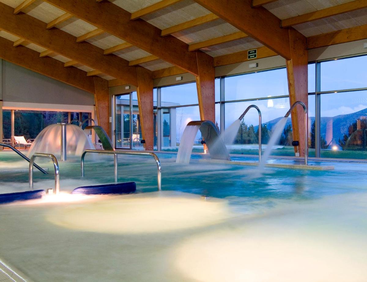 una piscina con fuentes de agua en un edificio en Hotel & Spa La Collada, en Toses