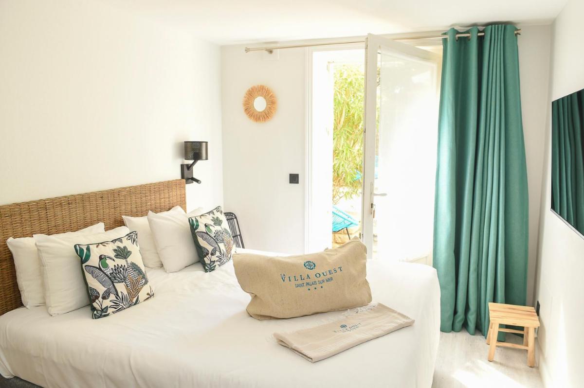Un ou plusieurs lits dans un hébergement de l'établissement The Originals Boutique Hôtel La Villa Ouest & Spa