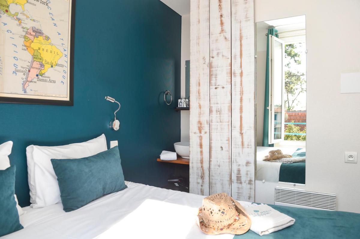 une chambre avec un lit et un mur bleu dans l'établissement The Originals Boutique Hôtel La Villa Ouest & Spa, à Saint-Palais-sur-Mer 53 autres photos