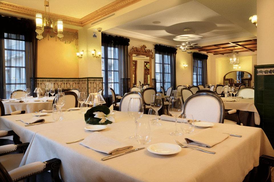 Un comedor con mesas y sillas con mantel blanco. en San Ramón del Somontano, en Barbastro