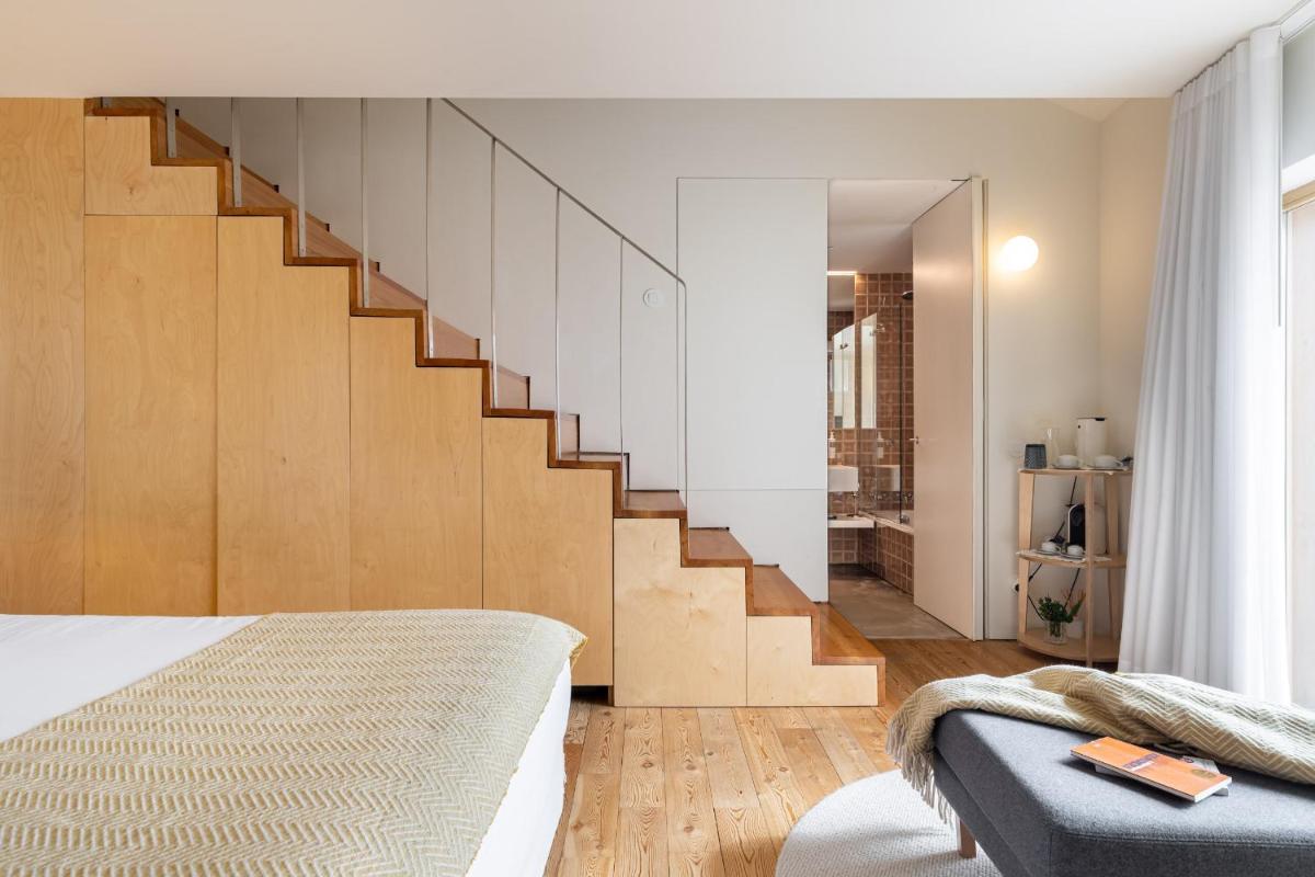 um quarto com uma cama e uma escada em Casas Da Lapa, Nature & Spa Hotel em Seia