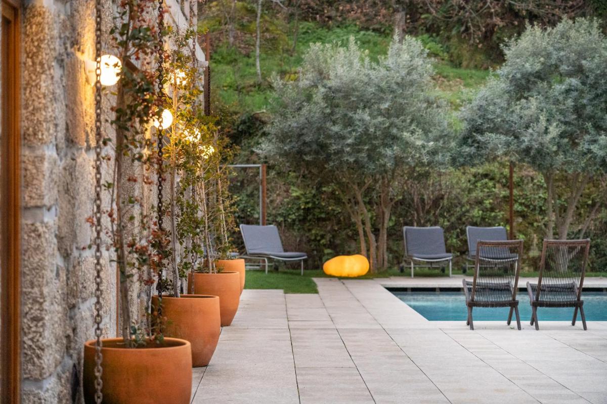 um pátio com cadeiras e uma piscina em Casas Da Lapa, Nature & Spa Hotel em Seia um pátio com cadeiras e uma piscina em Casas Da Lapa, Nature & Spa Hotel em Seia