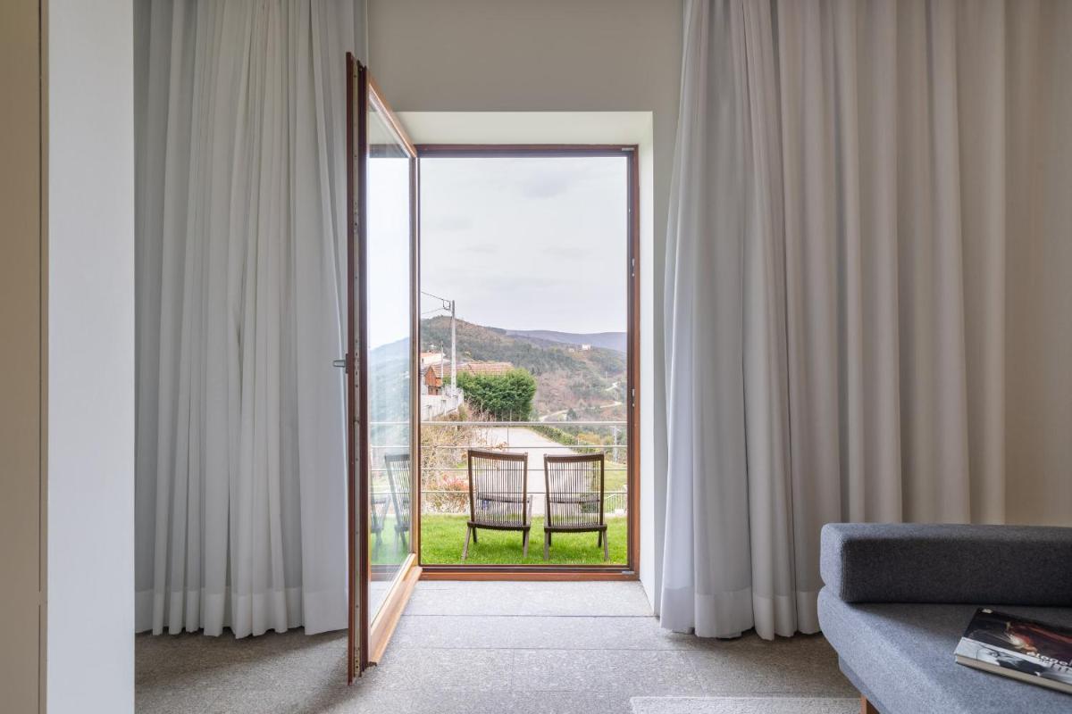 uma sala de estar com uma porta aberta para uma varanda em Casas Da Lapa, Nature & Spa Hotel em Seia mais 60 fotografias