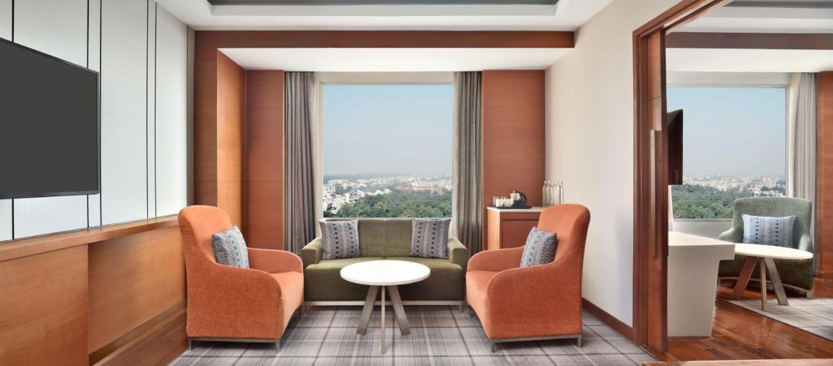 a hotel room with chairs and a table and a window at Hyatt Centric Janakpuri New Delhi in New Delhi
