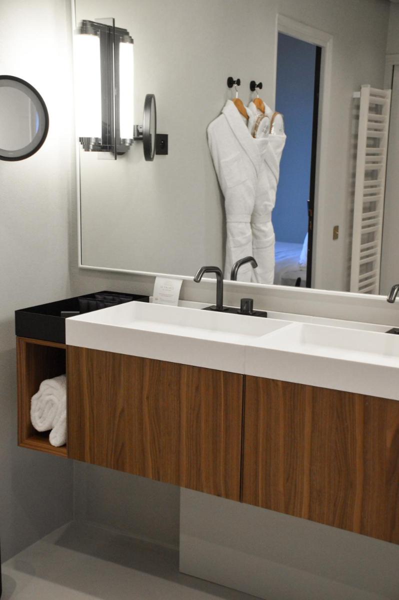 une salle de bains avec un lavabo et un miroir dans l'établissement Le Palace De Menthon, à Menthon-Saint-Bernard