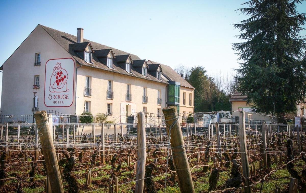 un bâtiment avec un panneau en face d'un vignoble dans l'établissement Hôtel-Spa Ô Rouge - Gevrey-Chambertin - Teritoria, à Gevrey-Chambertin