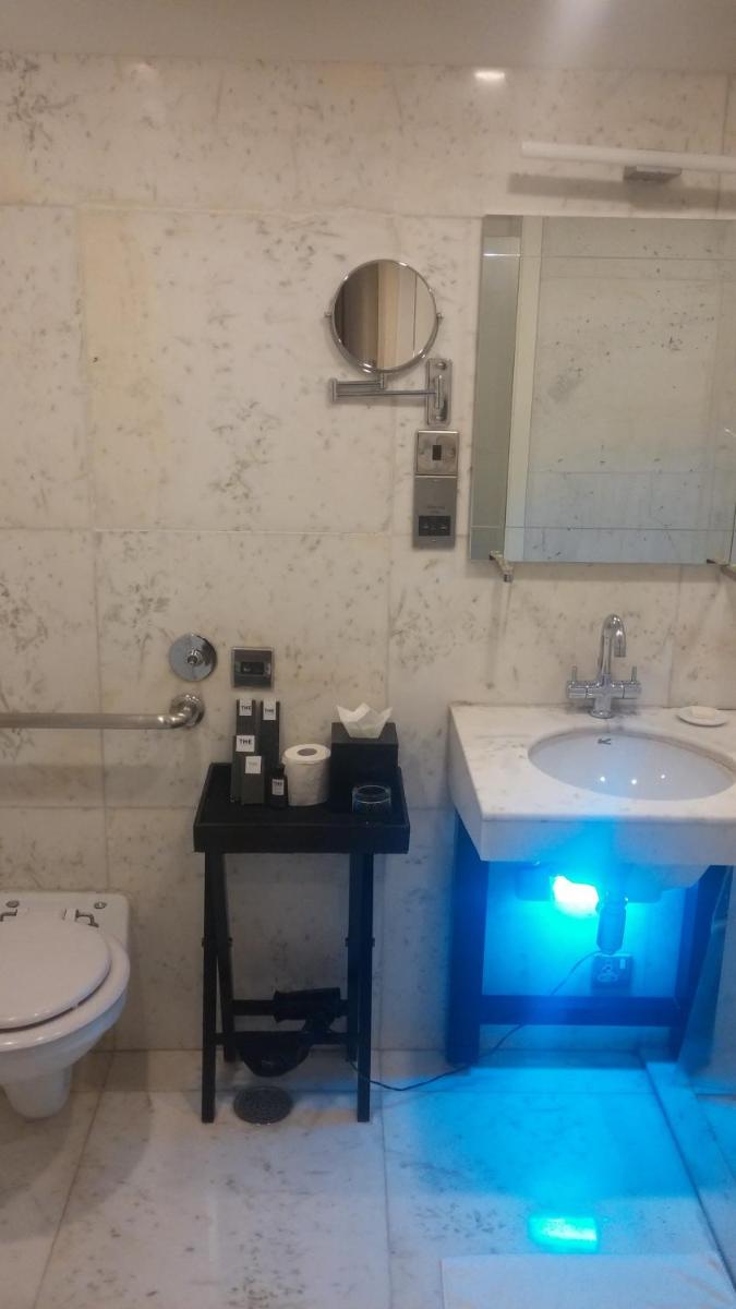 a bathroom with a sink and a toilet with a blue light at The Park Bangalore, MG Road in Bengaluru a bathroom with a sink and a toilet with a blue light at The Park Bangalore, MG Road in Bengaluru