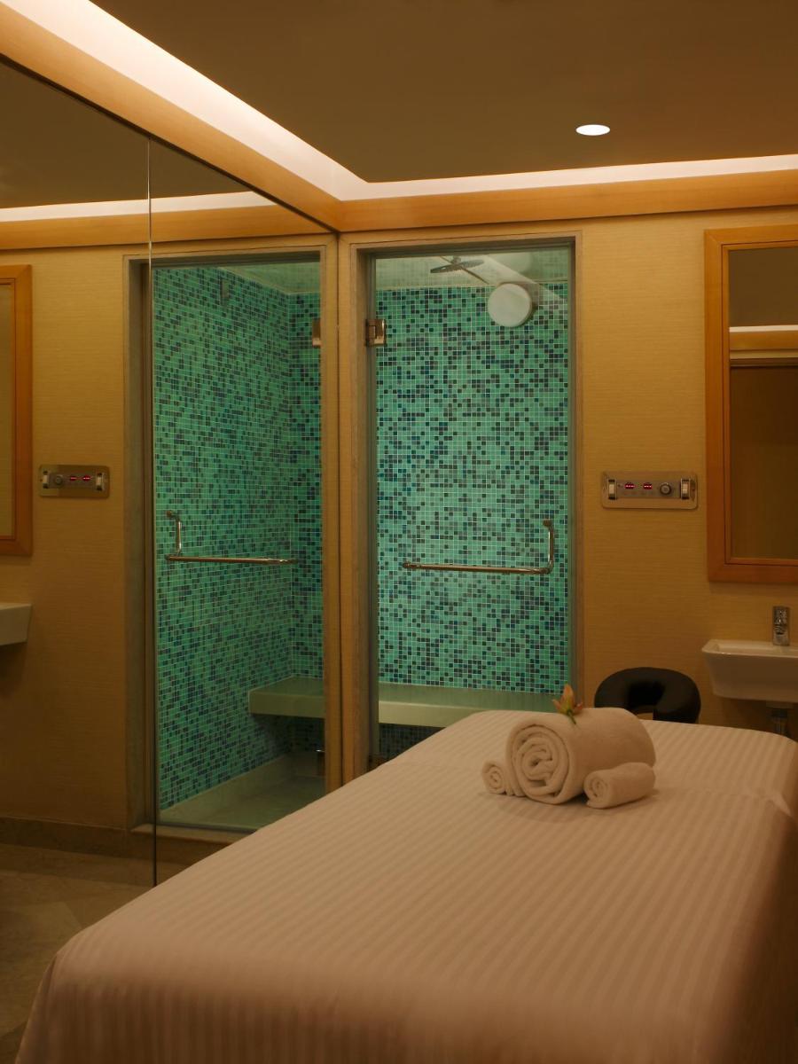 a bedroom with a bed and a glass shower at Lemon Tree Premier, Delhi Airport in New Delhi a bedroom with a bed and a glass shower at Lemon Tree Premier, Delhi Airport in New Delhi