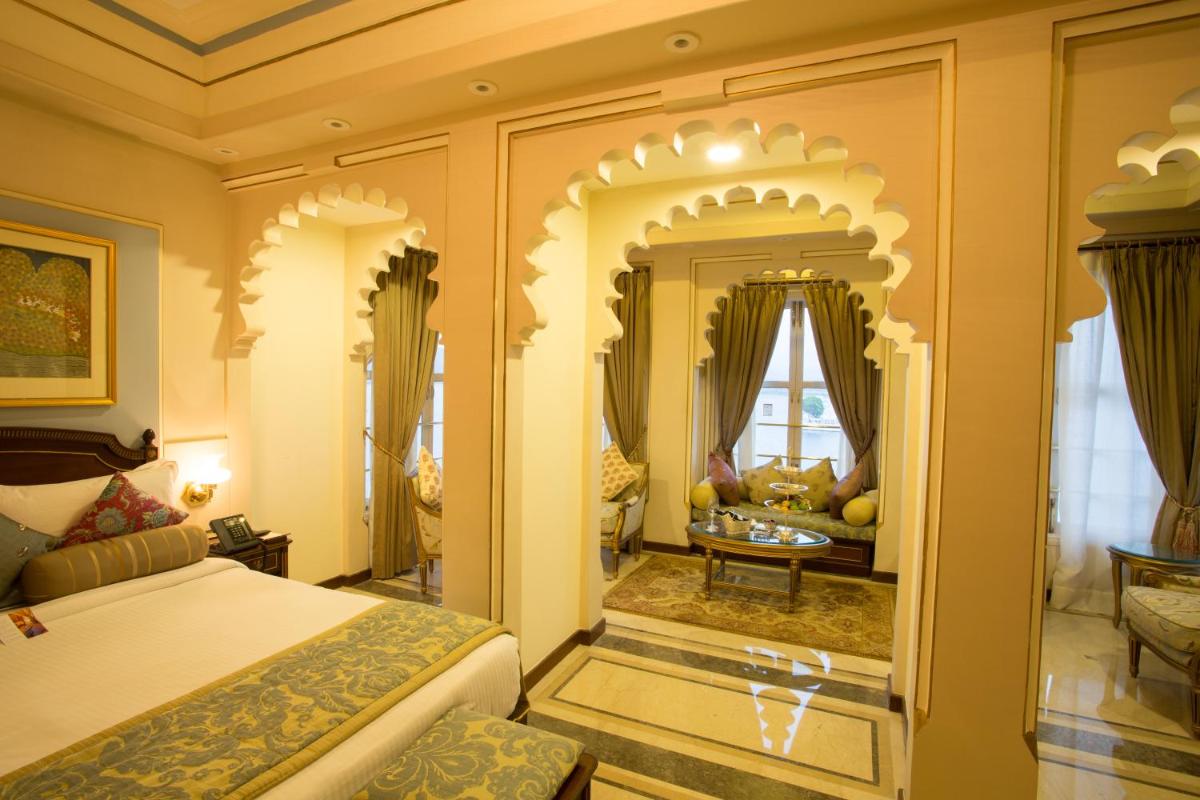 a bedroom with a bed and a living room at Taj Fateh Prakash Palace Udaipur in Udaipur