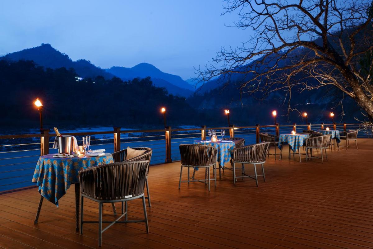 a row of tables and chairs on a deck at Anand Kashi by the Ganges Rishikesh - IHCL Seleqtions in Rishīkesh