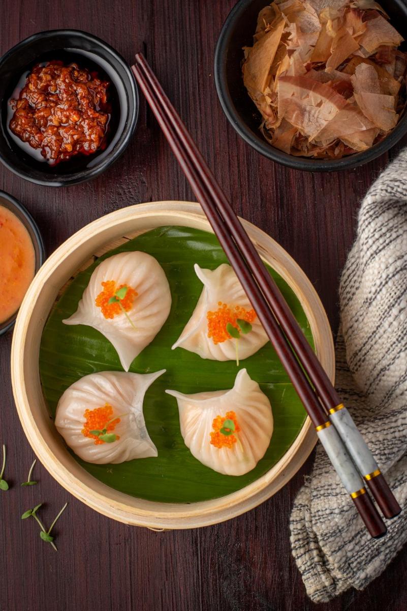 a bowl of food with dumplings on a wooden table at Radisson Blu Plaza Delhi Airport in New Delhi a bowl of food with dumplings on a wooden table at Radisson Blu Plaza Delhi Airport in New Delhi