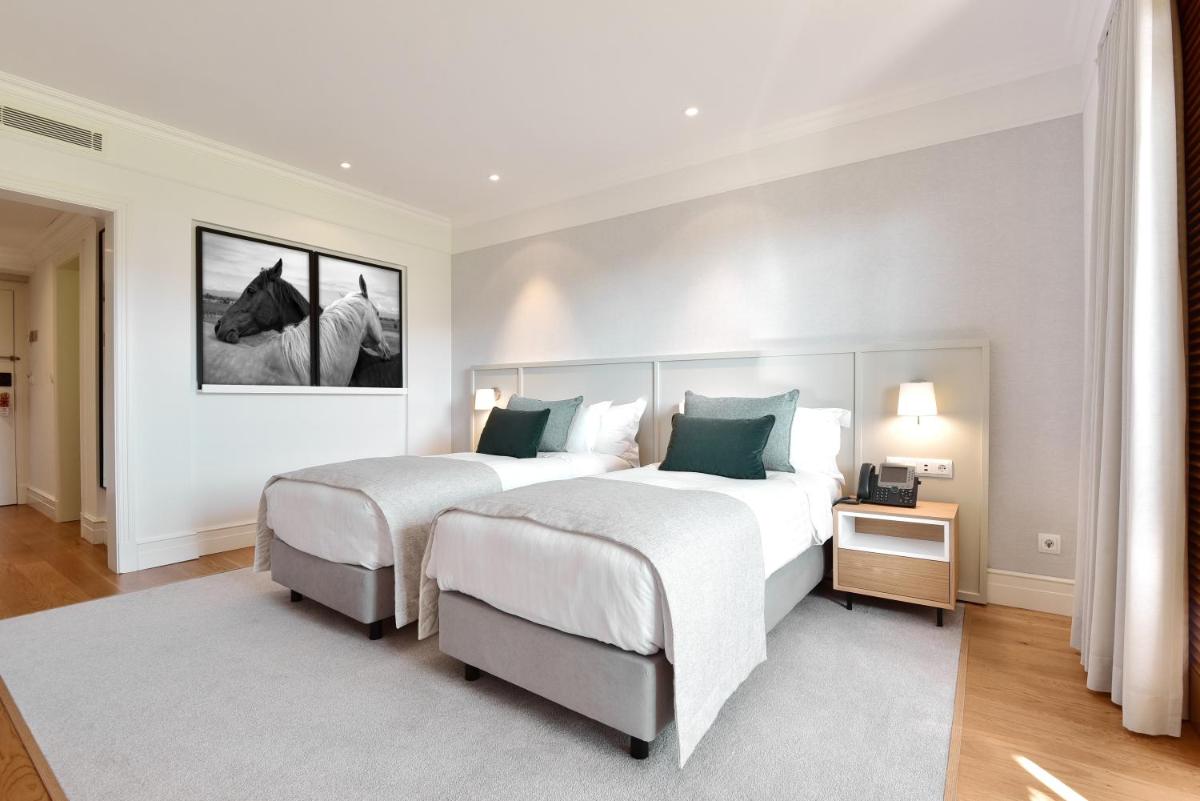 Uma cama ou camas num quarto em Dolce CampoReal Lisboa