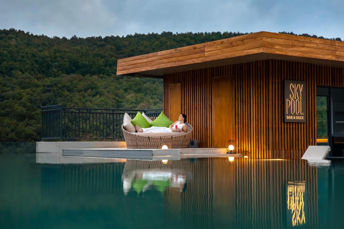 a man sitting in a chair next to a pool of water at Hyatt Regency Dehradun Resort and Spa in Dehradun