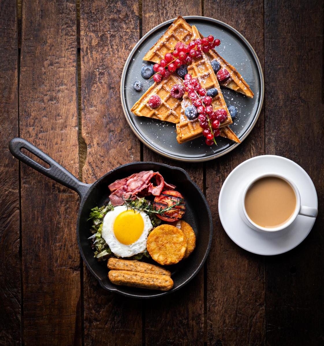 a plate of waffles with an egg and a cup of coffee at Hyatt Regency Dehradun Resort and Spa in Dehradun
