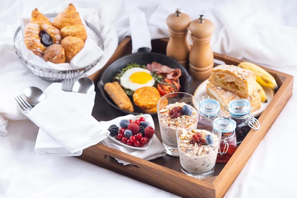 a tray of breakfast food on a bed at Hyatt Regency Dehradun Resort and Spa in Dehradun