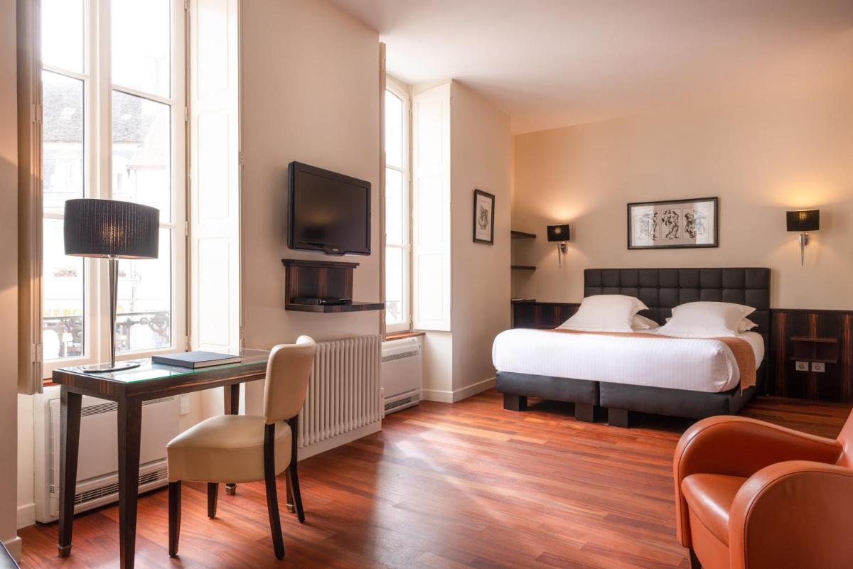 une chambre avec un lit, un bureau et une télévision dans l'établissement L'Hôtel, à Beaune