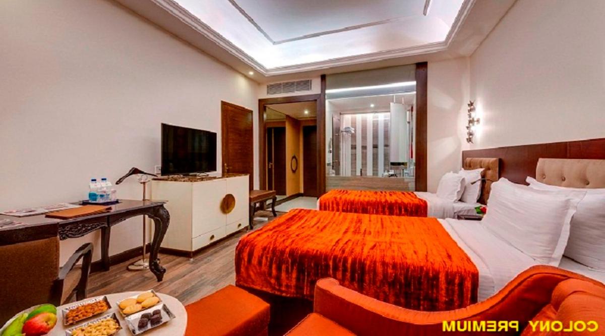 a hotel room with two beds and a television at Hotel Hindusthan International, Kolkata in Kolkata