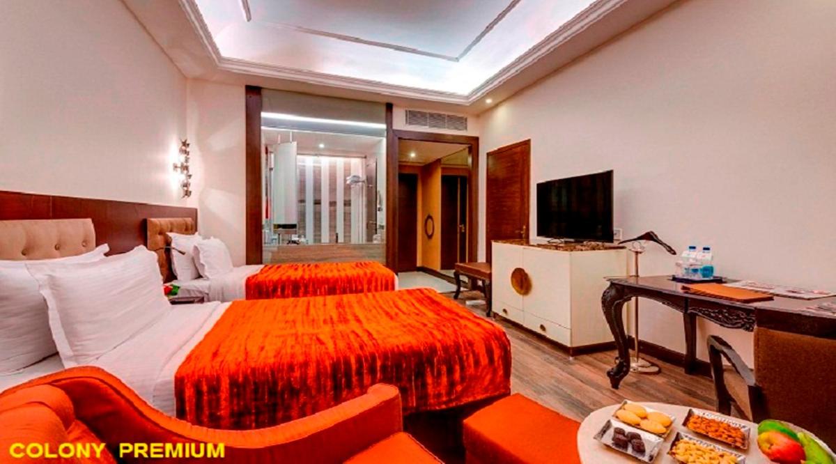 a hotel room with two beds and a television at Hotel Hindusthan International, Kolkata in Kolkata
