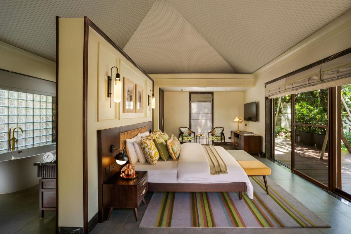 a bedroom with a large bed and a bathroom at Anand Kashi by the Ganges Rishikesh - IHCL Seleqtions in Rishīkesh